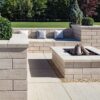 Techo Bloc Travertina wall, slab, and cap used to create cohesive fire feature and seat wall gathering area.